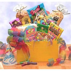 a yellow box filled with lots of candy and confetti on top of a wooden table