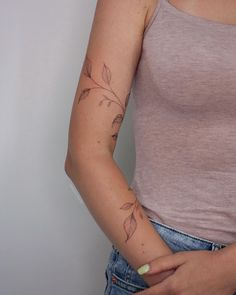 a woman with a flower tattoo on her left arm and right arm behind her back