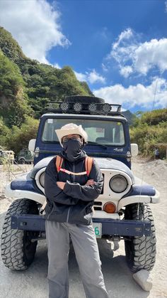 a man wearing a gas mask standing in front of a jeep