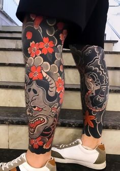 a person with tattoos on their legs and leggings is standing near some stairs