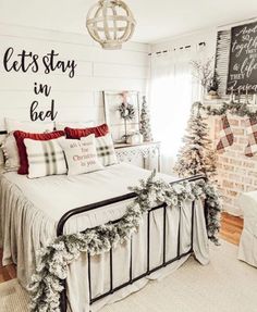 a bed room with a neatly made bed and christmas decorations on the wall above it