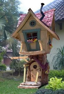 a bird house made out of wood in the yard