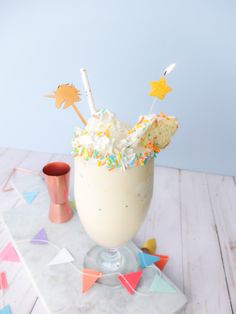 a drink with sprinkles and candles in it