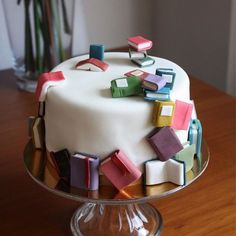 a white cake with colorful icing on top of a wooden table