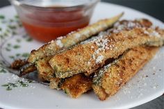 some fried food on a white plate with dipping sauce