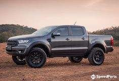 a grey truck parked on top of a dirt field