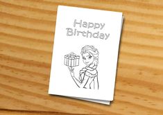 a birthday card with an image of a princess holding a present on top of a wooden table