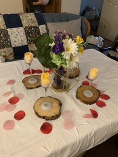 the table is set up with candles and flower centerpieces on top of it