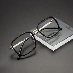 Featuring a rectangle design crafted from mixed materials, these eyeglasses effortlessly blend classic and modern elements. The adjustable nose pads provide a custom fit, ensuring both comfort and stability. Despite their sturdy construction, the glasses are lightweight, offering all-day wear without strain. The frame exudes elegance and sophistication, making them a fashionable choice for any occasion. Modern Square Frame Sunglasses For Office, Black Rectangular Sunglasses With Metal Frame, Elegant Adjustable Rectangular Sunglasses, Metal Bridge, Rectangle Design, Rectangle Eyeglasses, Eyeglass Lenses, Modern Elements, Classic Metal