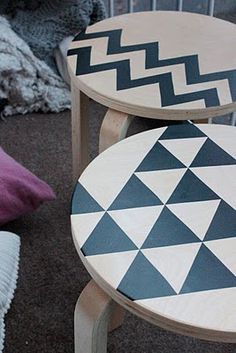 two wooden stools with geometric designs on them