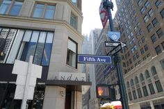 a street sign on the corner of fifth ave and new york city blvd