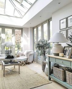 a living room filled with lots of furniture and windows covered in white flowers on top of them