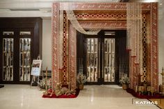 an elaborately decorated entrance to a building with red and gold decorations on the floor