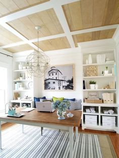 a living room with a laptop on the table and bookshelves in front of it