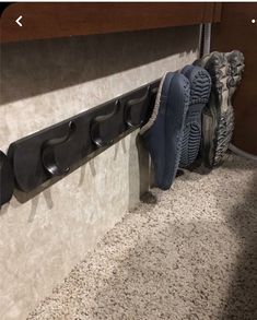 two pairs of shoes are hanging on the wall next to a pair of running shoes