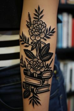 a woman's arm with flowers and books on it