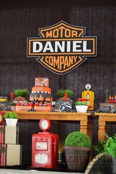 a table topped with lots of toy trucks and cars next to a sign that says motor daniel company