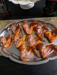 several pieces of chicken sitting on top of a metal tray next to a bottle of beer