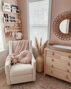 a baby's room with pink walls and furniture