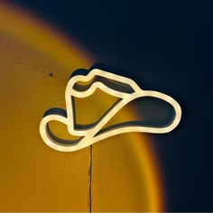 a neon sign on the side of a wall with a shoe hanging from it's side