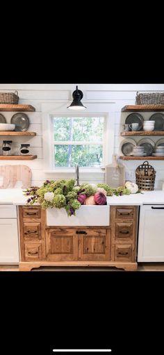 a kitchen with wooden cabinets and white counter tops next to open shelves filled with dishes