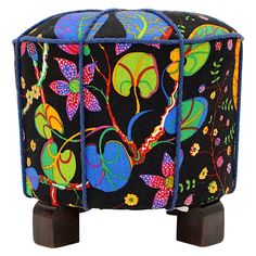 a colorfully decorated stool with wooden legs