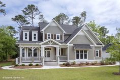 a gray house with white trim on the front porch and two story entryway to the second floor