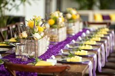 a table set up with purple and yellow decorations