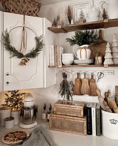 a kitchen with white cabinets and shelves filled with christmas decorations