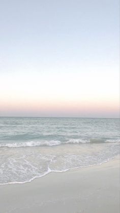 an empty beach with waves coming in to shore