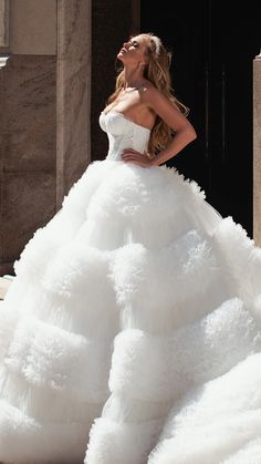 a woman in a white wedding dress posing for the camera