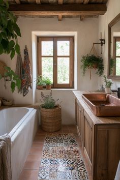 a bath room with a tub a sink and some plants on the windows sill