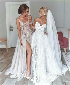 two women in wedding dresses standing next to each other