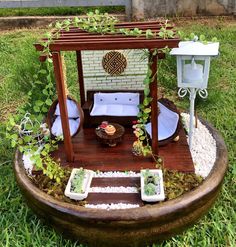 a miniature garden is set up in a potted planter on the grass outside