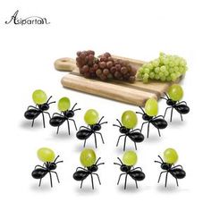 a bunch of green bugs sitting on top of a table next to grapes and bread