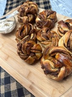 cinnamon rolls on a cutting board with dip