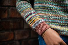 a close up of a person wearing a colorful sweater