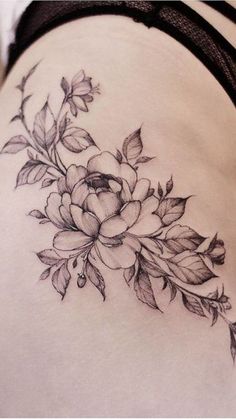 a woman's stomach with flowers and leaves tattoo on her side ribcage