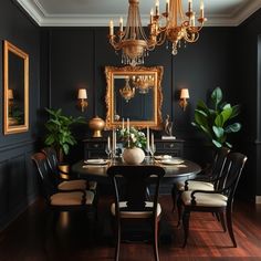 an elegant dining room with black walls and wooden floors, chandelier above the table