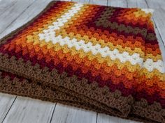 a crocheted blanket laying on top of a wooden floor