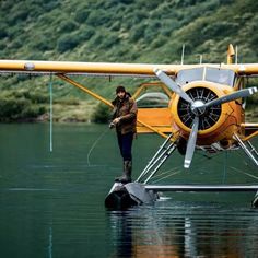 a person standing in the water next to an airplane