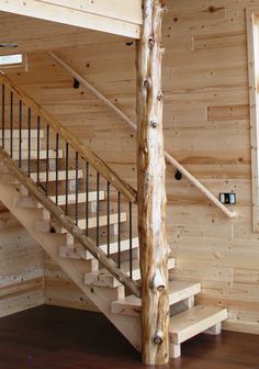 a wooden staircase in a log cabin with wood flooring and railings on the sides