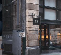 the corner of a building with a street sign on it's side next to a store front