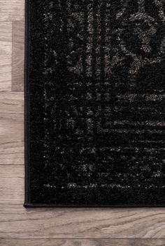 a black area rug on top of a wooden floor