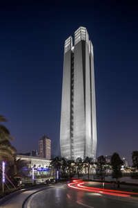 a very tall building sitting in the middle of a city at night with lights on