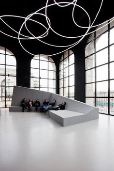 people sitting on benches in an empty room