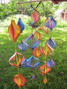 colorful wind chimes hanging from a tree in the grass