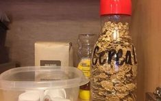 an empty plastic container sitting on top of a counter next to a blender and other kitchen items