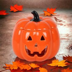 an orange pumpkin sitting on top of leaves