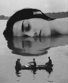 a woman floating on top of a body of water next to two men in a boat